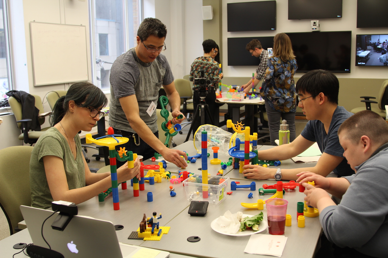 An image showing a group of four people participating in a Create-a-Thon, using building
toys.